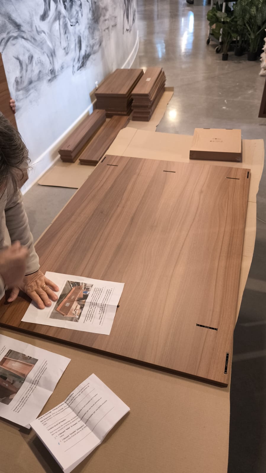 Panneaux décor bois disposés à plat sur une protection en carton avant l’assemblage de la jardinière